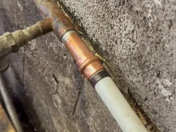 Copper supply line repair being completed in a wall opening for Plumbing Services in Lakewood, CA