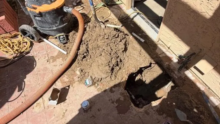 Slab access hole with repair tools nearby for Slab Leak Detection & Repair in Lakewood, CA